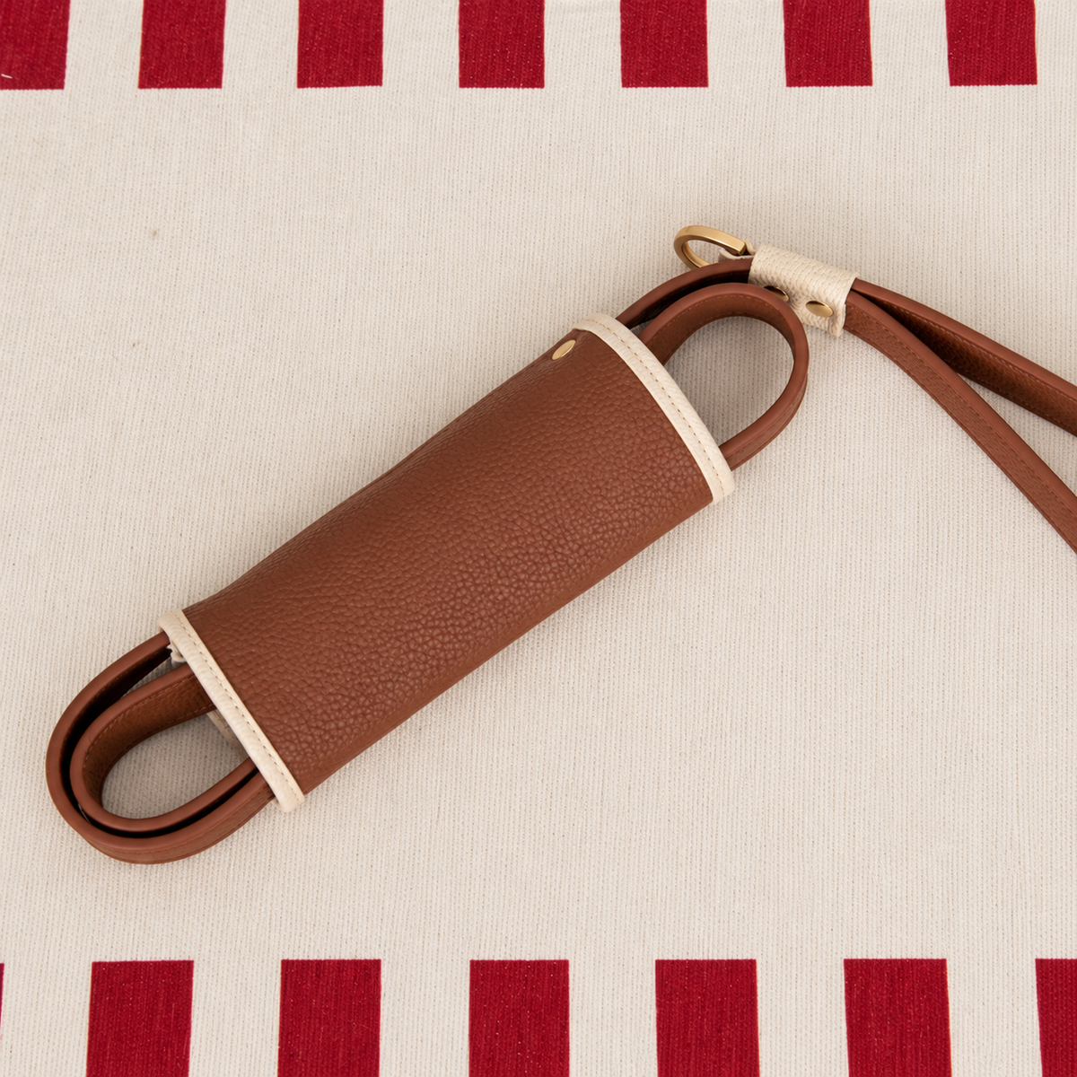 Matching brown leash folded into its cream-edged storage wrap