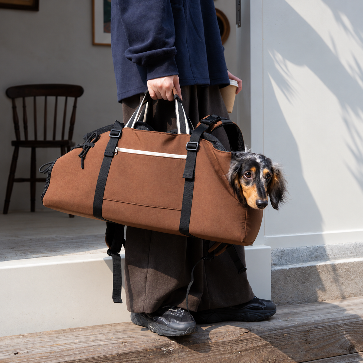 Brown three-way carrier carried by the striped top handles